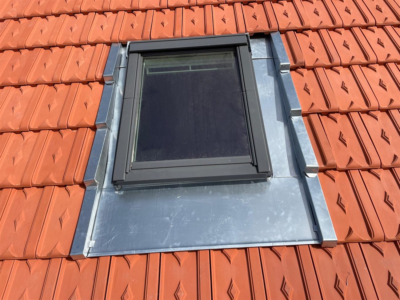 Détail d'un Velux intégré dans une couverture en tuiles